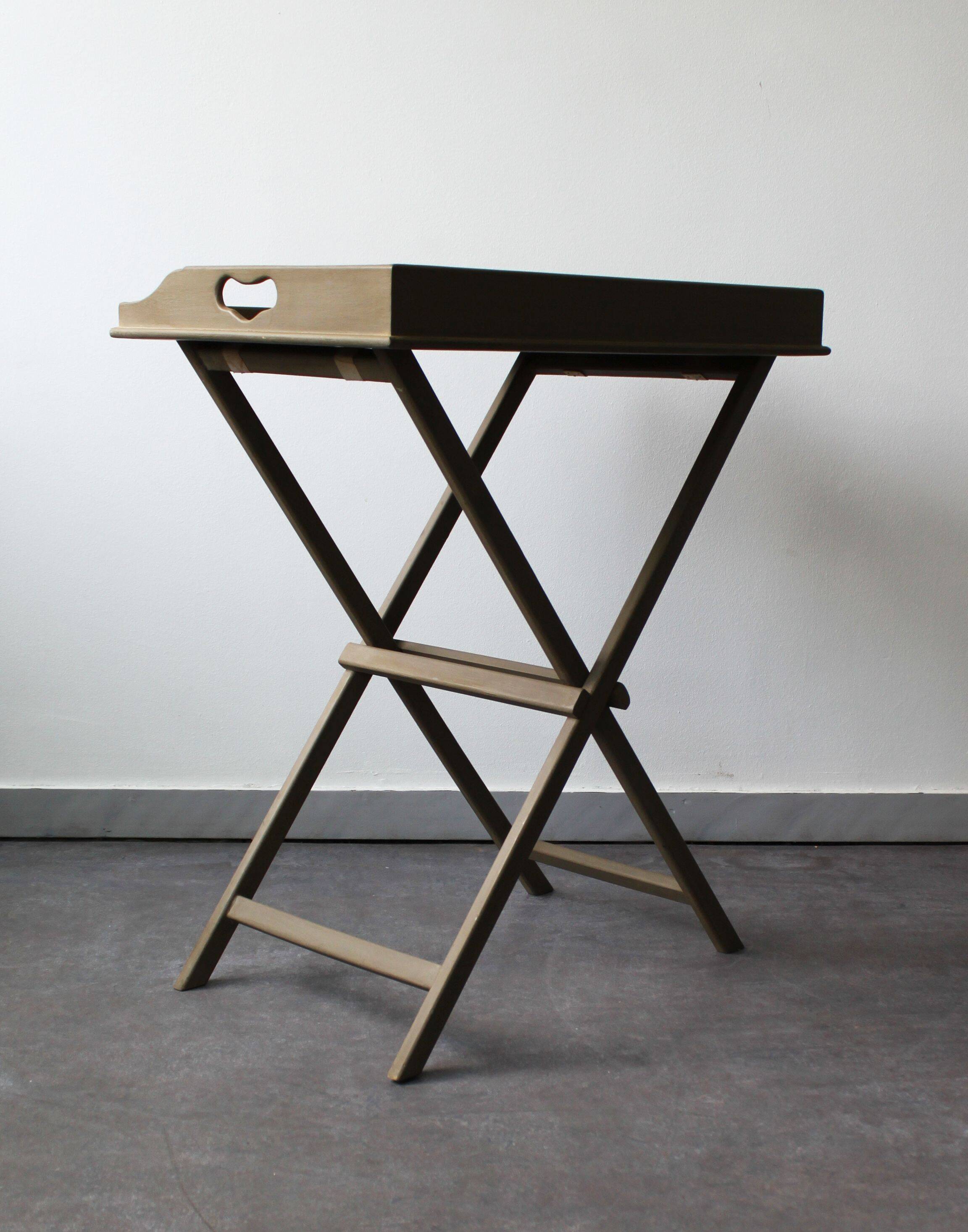 Folding and removable service tray in taupe-painted wood.