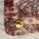 Pink marble trivet with brass ball feet.