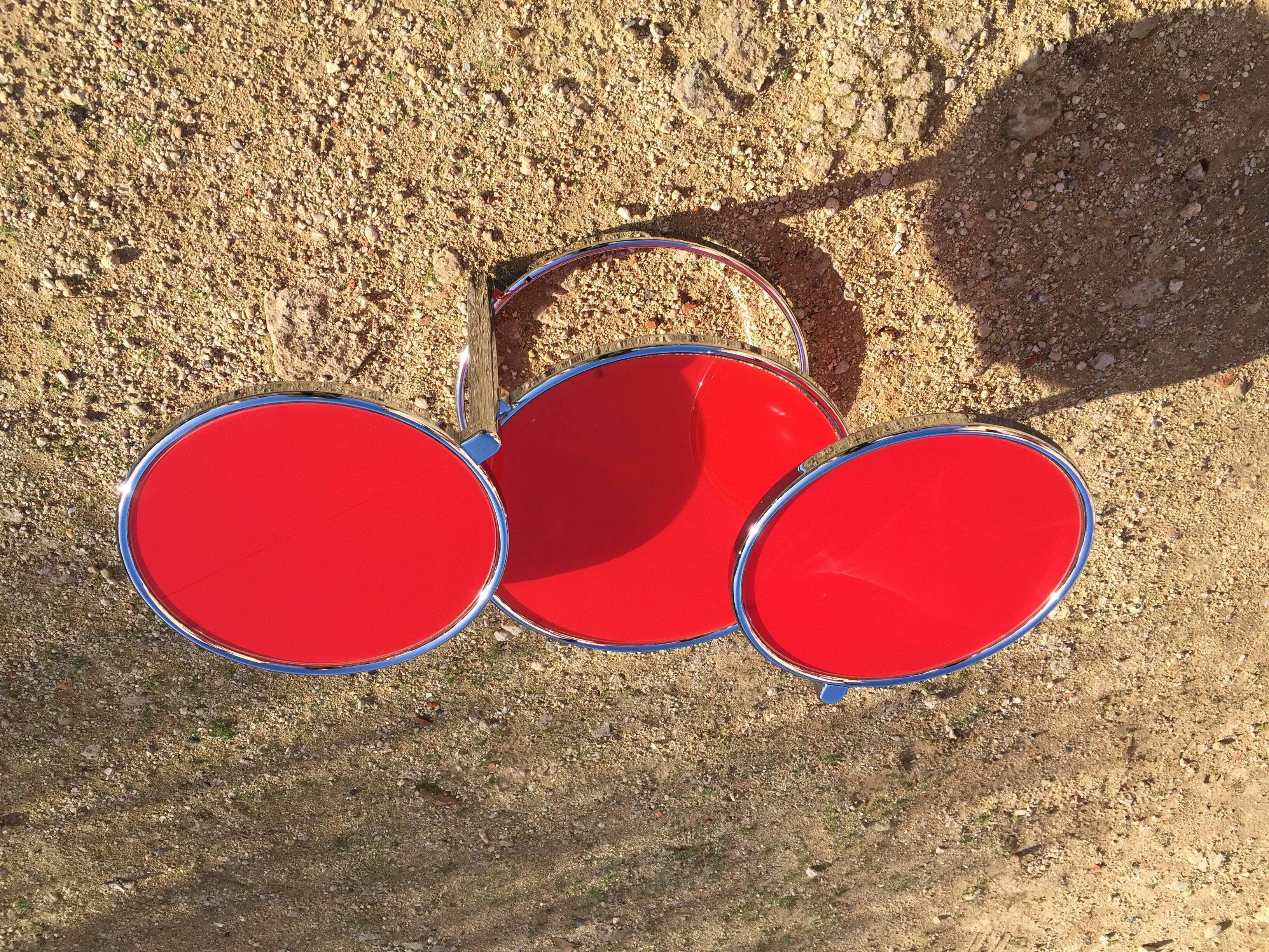 Table basse trois plateaux pivotants en verre rouge et métal chromé