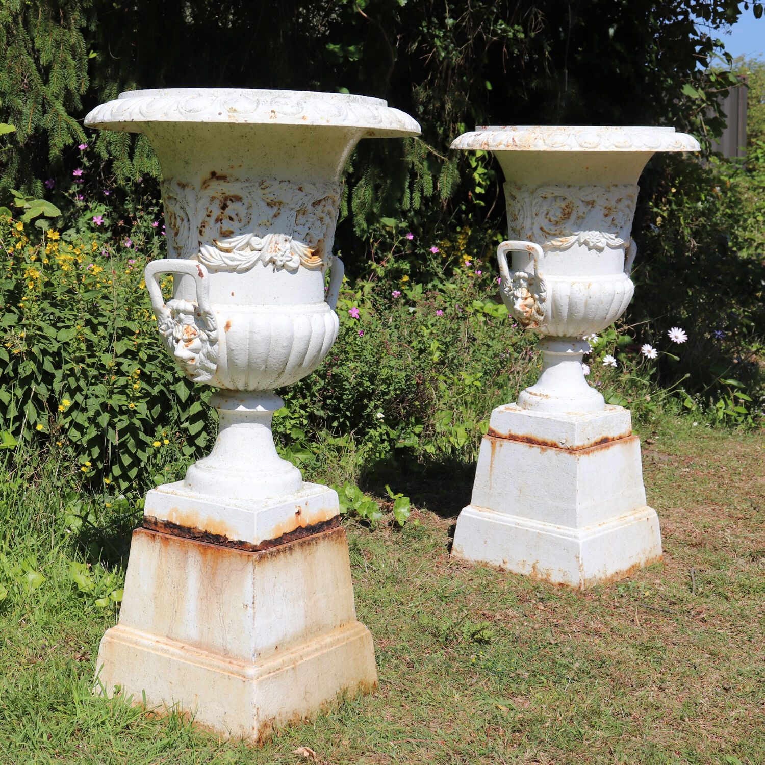 Pair of cast iron urns on plinth