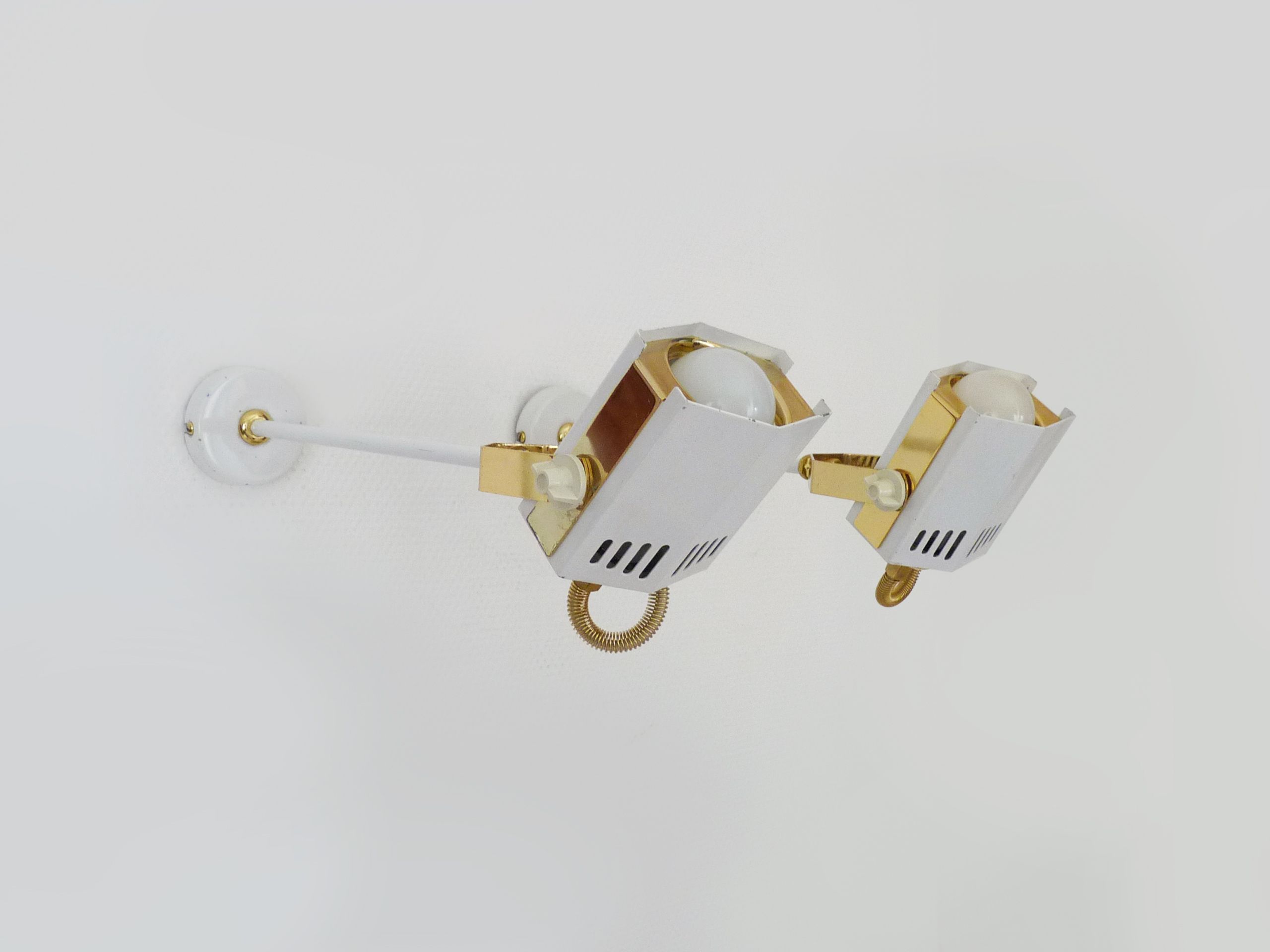 Pair of spot wall lamps adjustable design in white metal and brass. Year 80