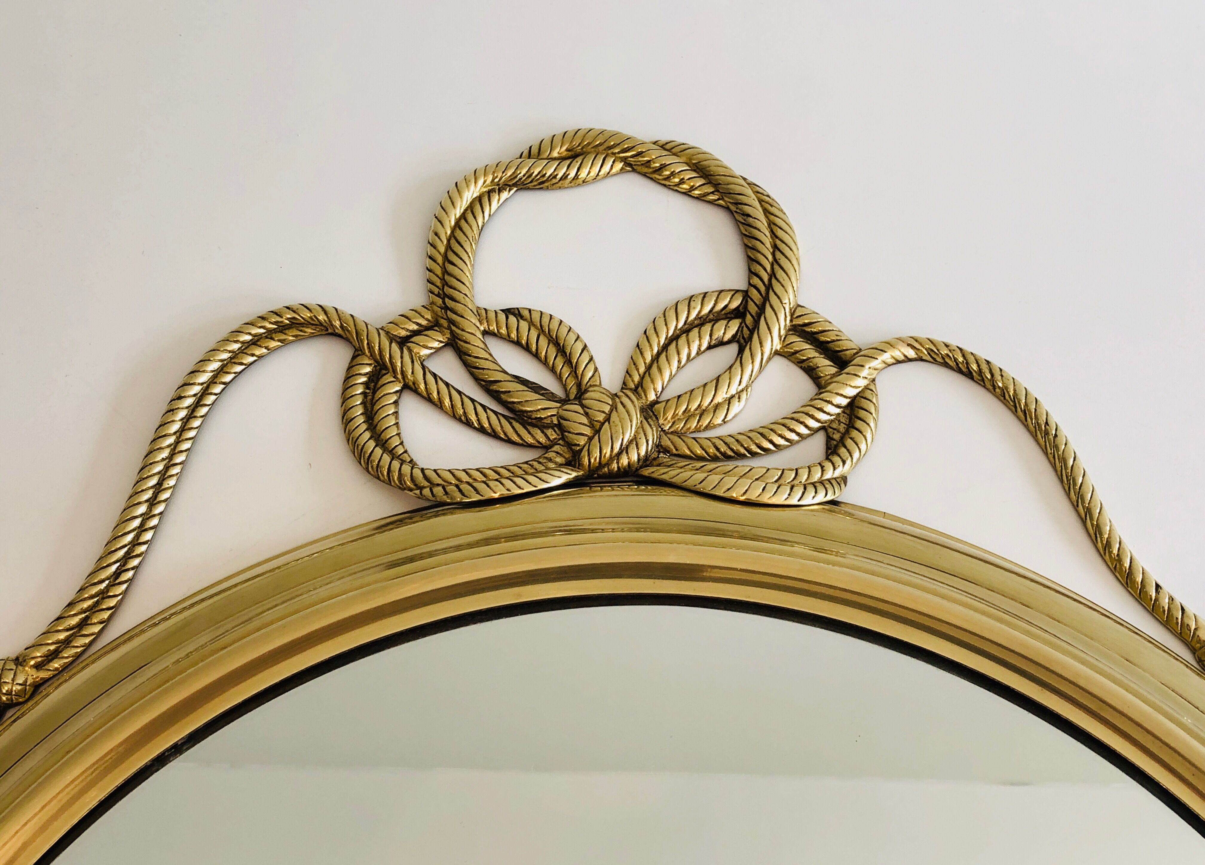 Oval Decorative Mirror in Brass decorated with an Important Twisted Knot