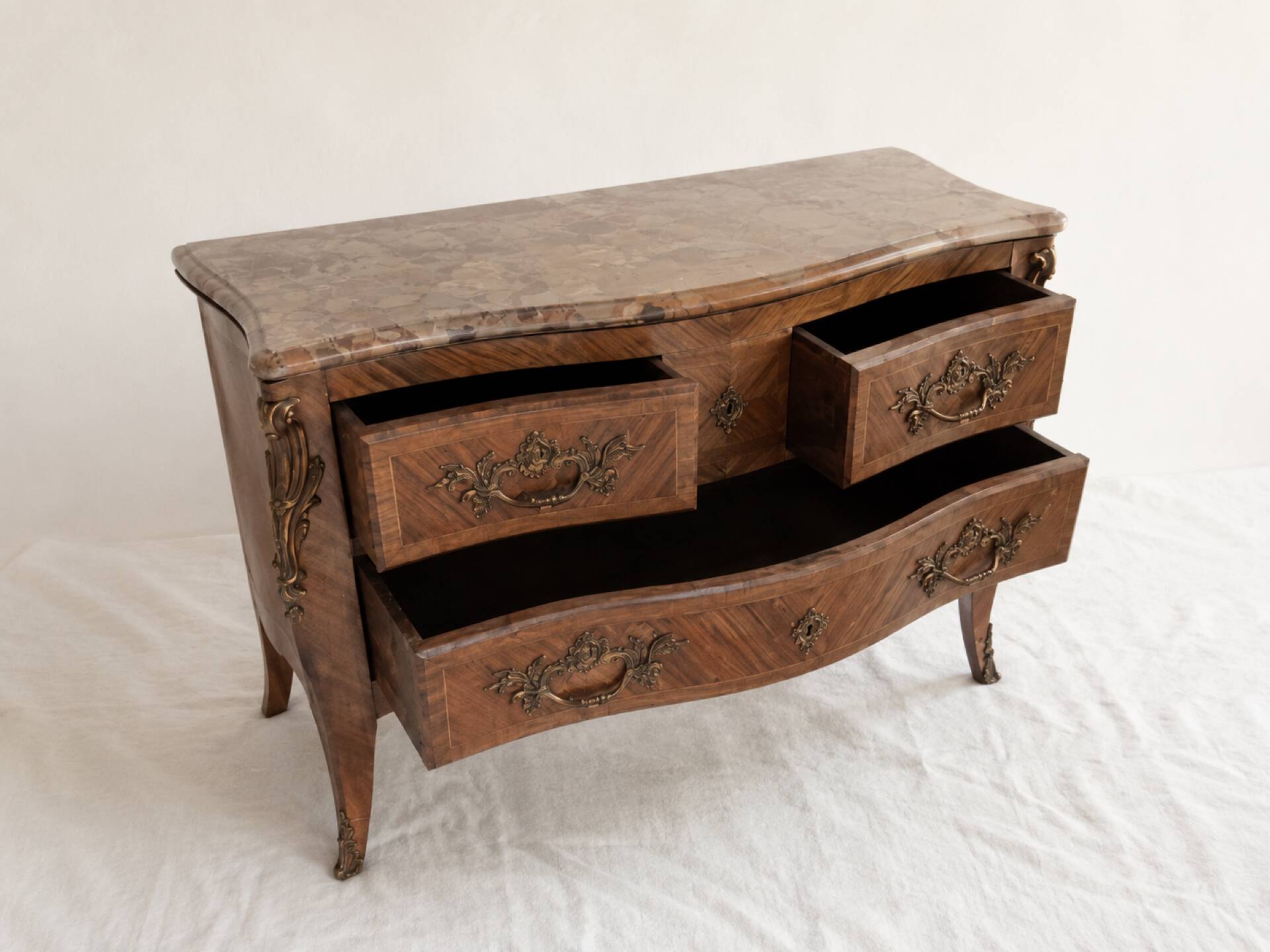 Curved Louis XV style commode in marquetry, veined marble and ornamentation.