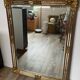 Large Deknudt mirror in gilded wood and glazing beads