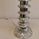 Table lamp made of transparent crystal glass and silver colored spacers.