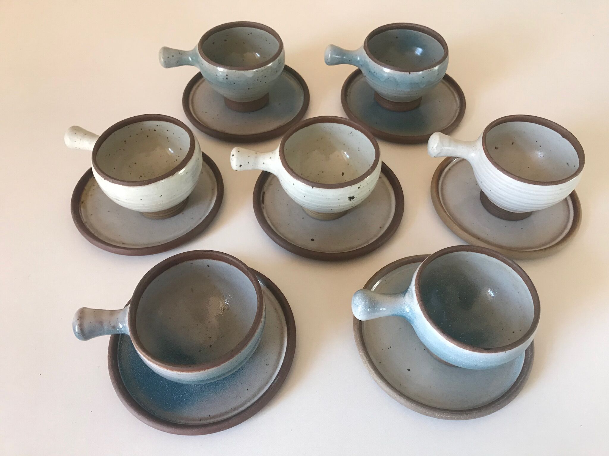 Lot 7 cups and saucers sandstone by Roger Jacques