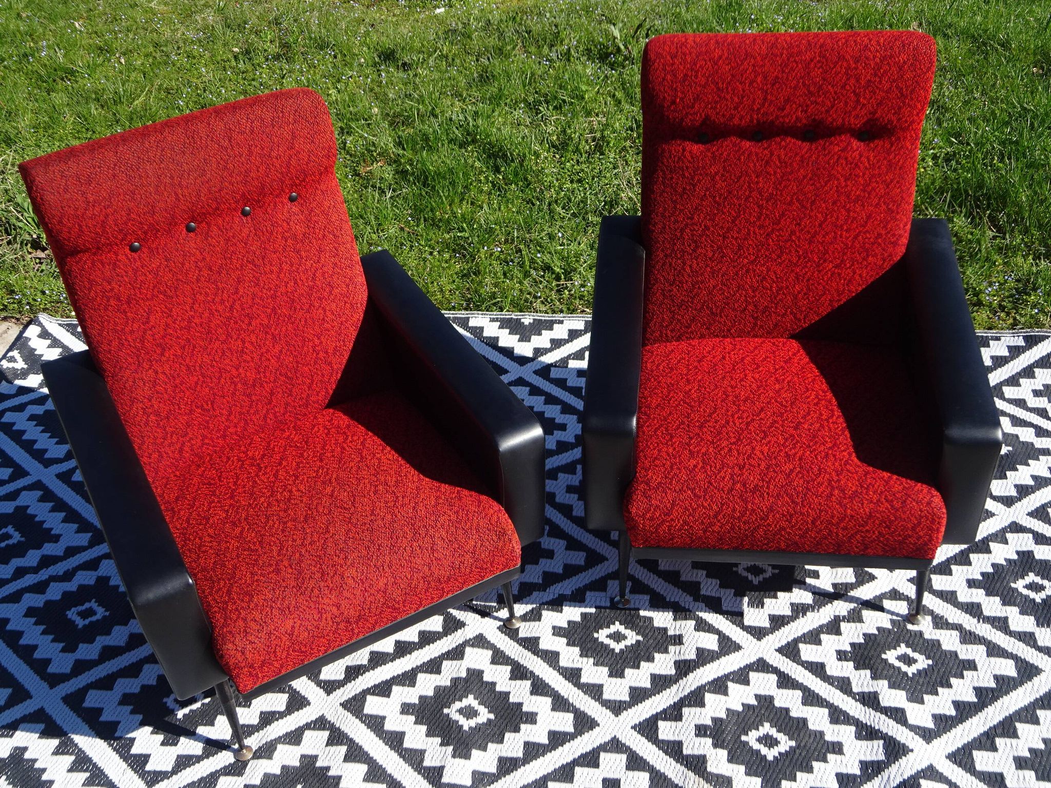 Pair of vintage armchairs in black faux leather and red fabric.