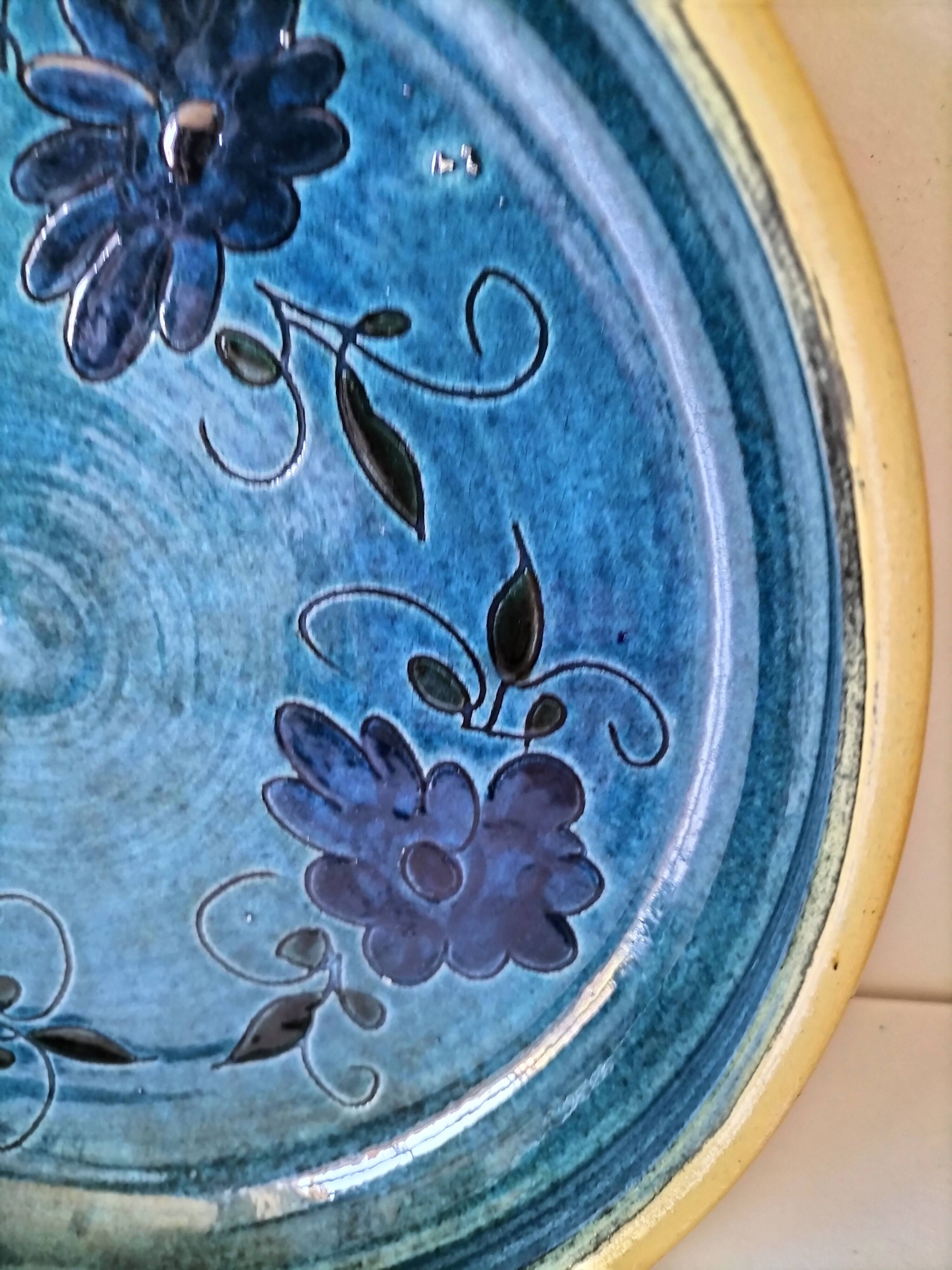 Blue floral glazed stoneware plate with a yellow rim.
