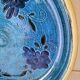 Blue floral glazed stoneware plate with a yellow rim.