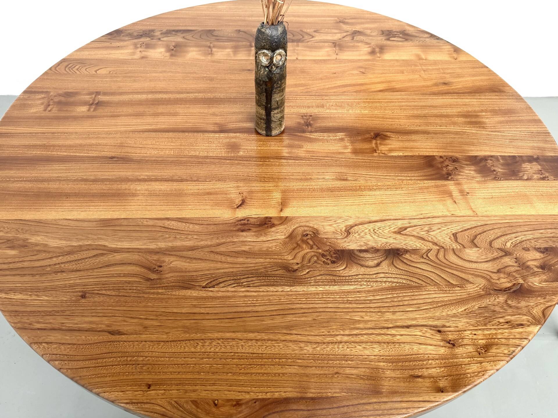 Modernist round table in solid elm, crossed legs.