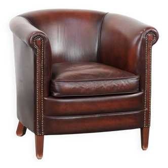 Fauteuil club en cuir de vache en bon état dans une couleur rouge/marron luxueuse.