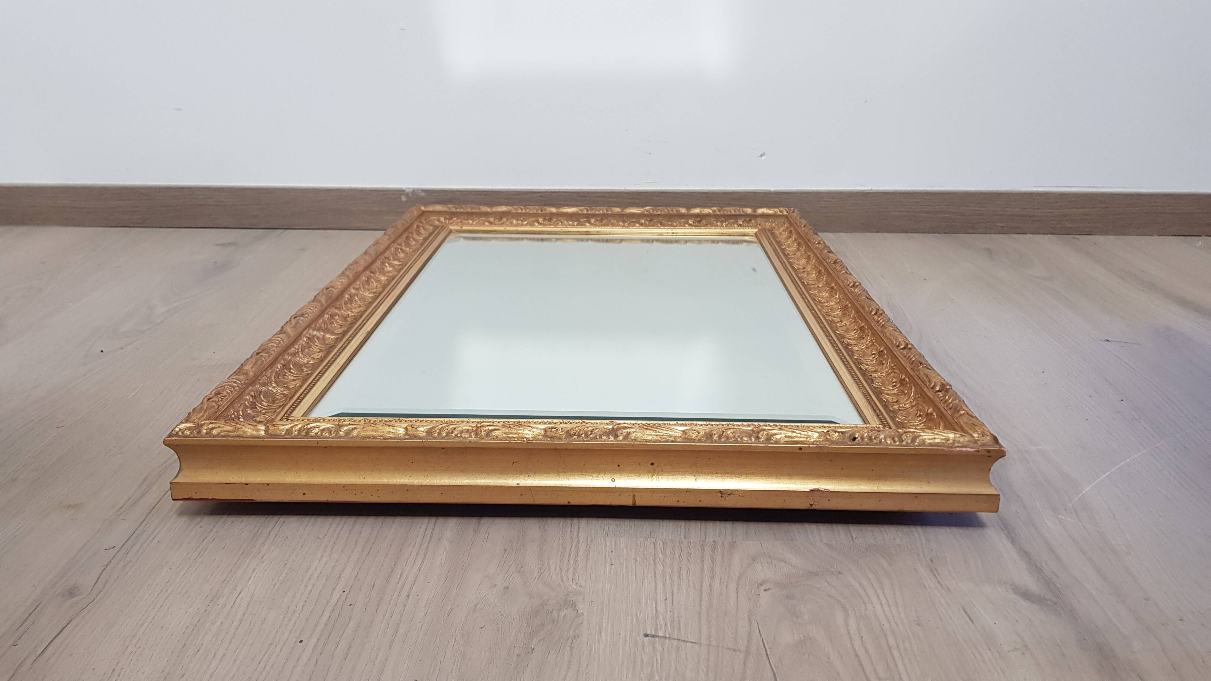 Mirror in gilded stucco wood and beveled glass