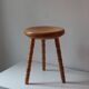 Vintage en bois tourné tabouret du milieu du siècle avec un siège épais.