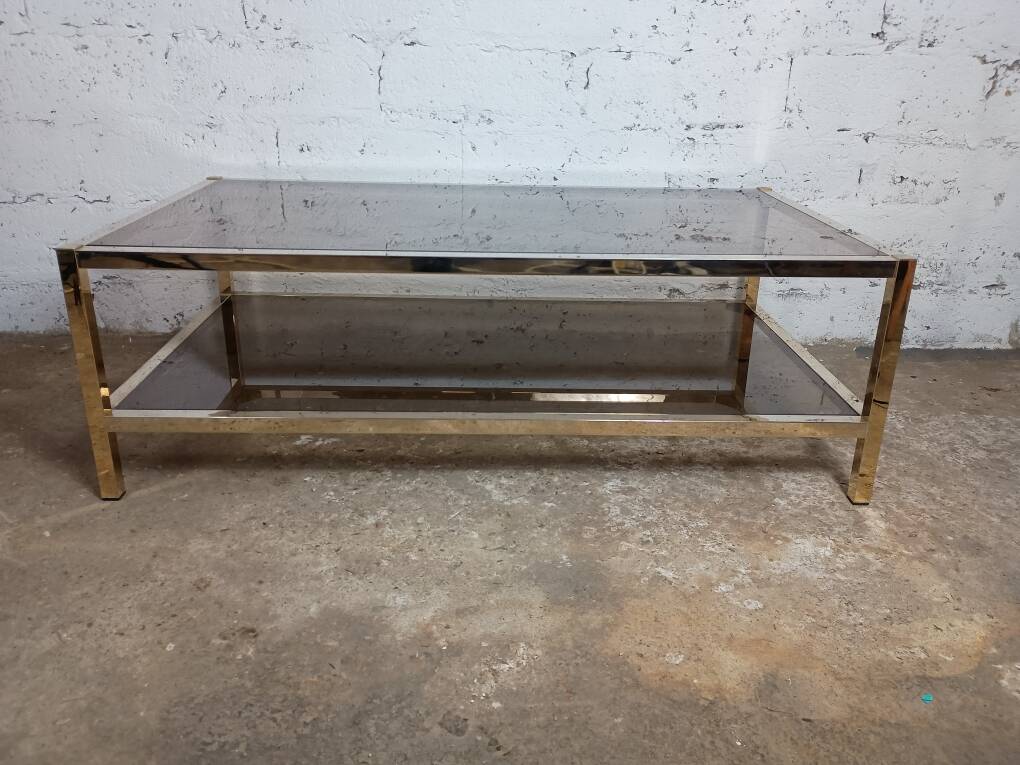 1970s coffee table in brass with a double smoked glass top.