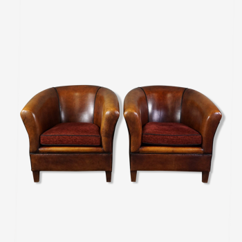 Set of 2 sheepskin club chairs with black piping and fabric cushions