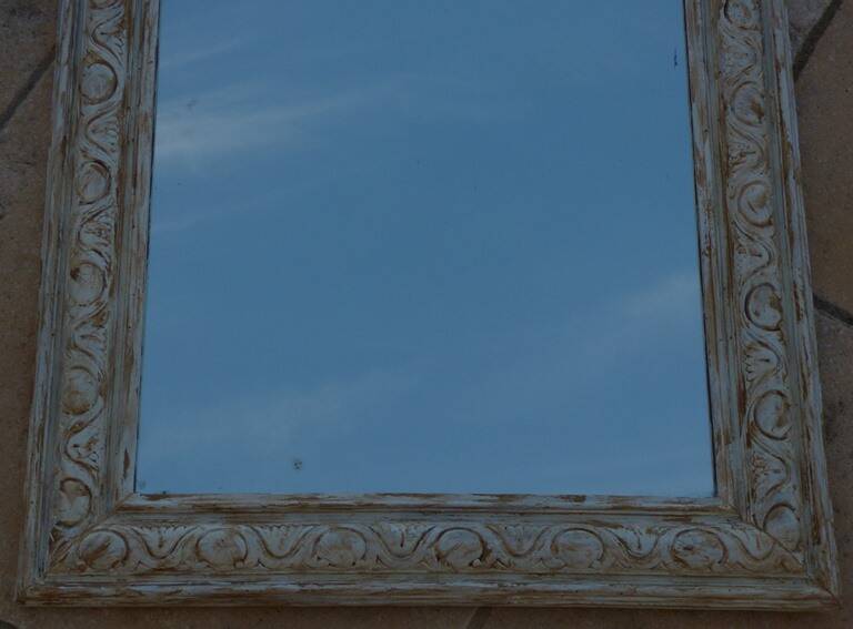 Chic and stylish old mirror with carved wooden frame in limed white and gold