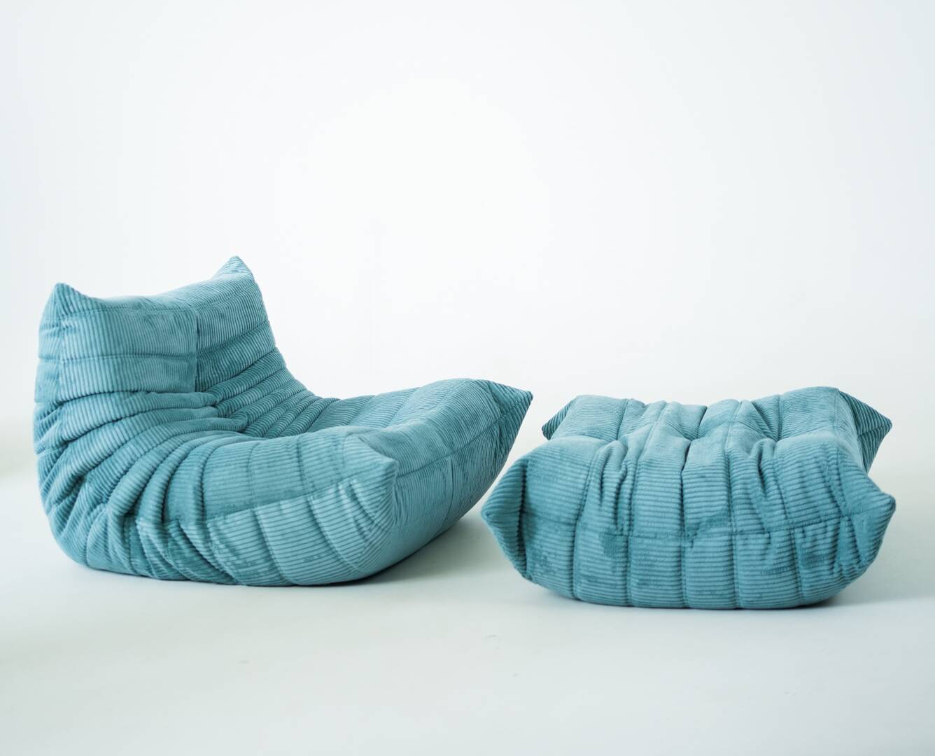 Ensemble de fauteuil et pouf Togo en velours côtelé bleu clair.
