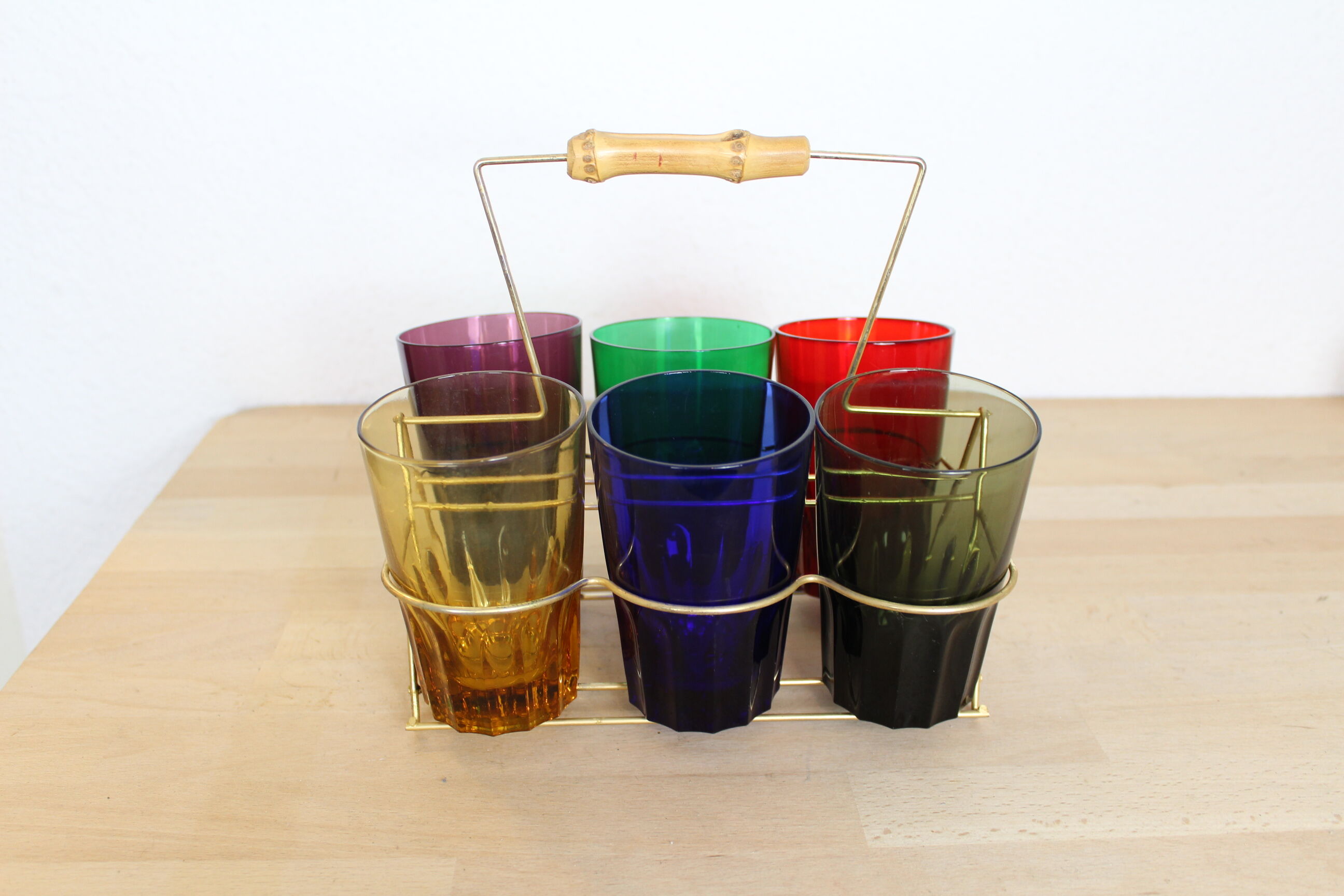 Set of 6 coloured glasses in their brass holder, basket