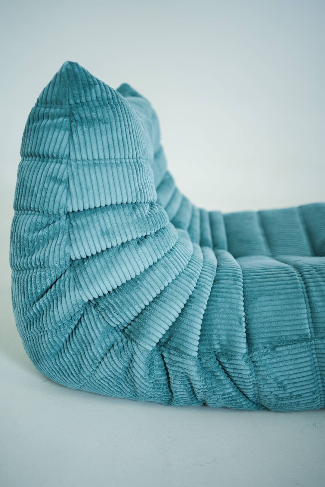 Ensemble de fauteuil et pouf Togo en velours côtelé bleu clair.