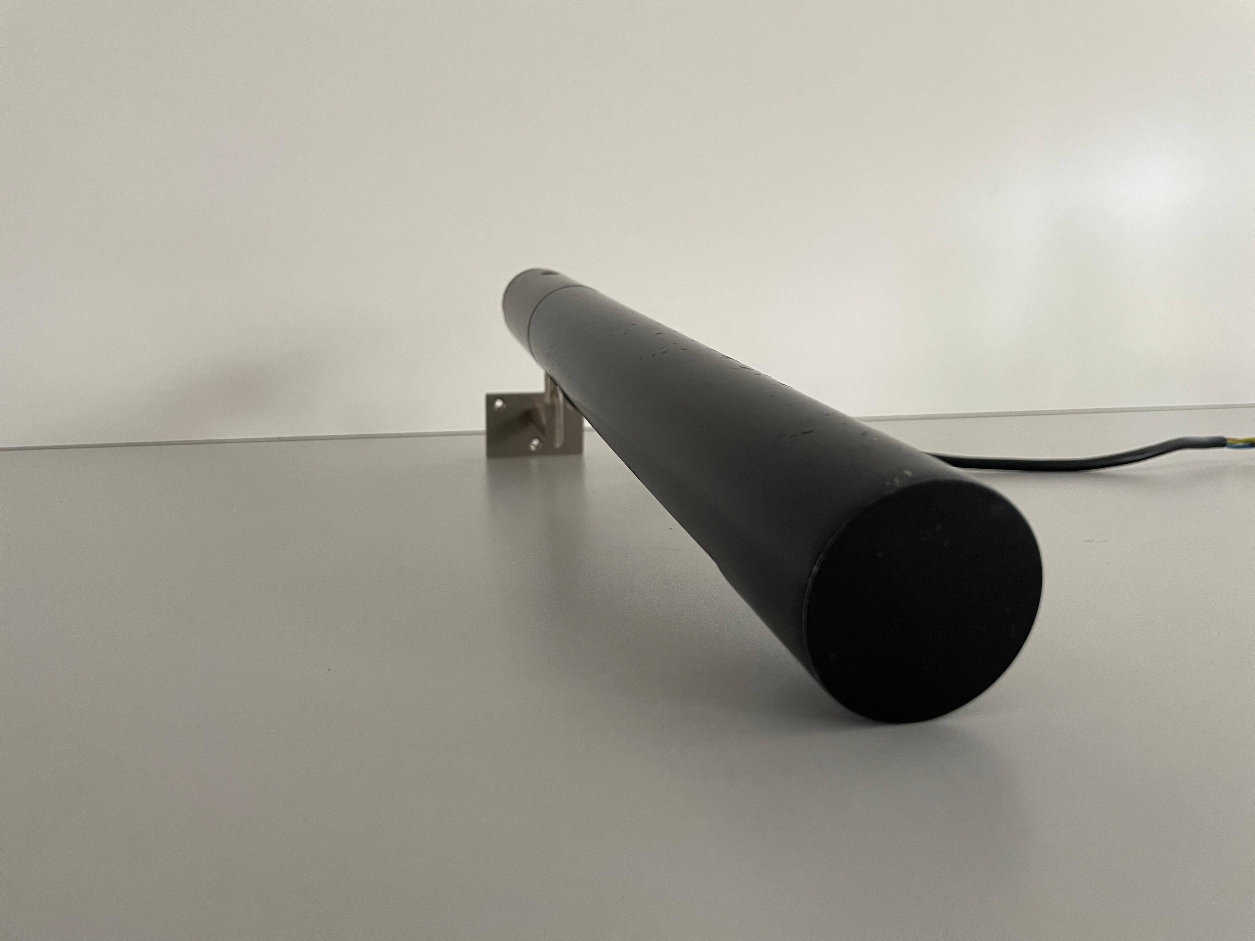 Minimalist black metal wall light with a cylindrical design, 1960s, Germany.