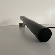 Minimalist black metal wall light with a cylindrical design, 1960s, Germany.