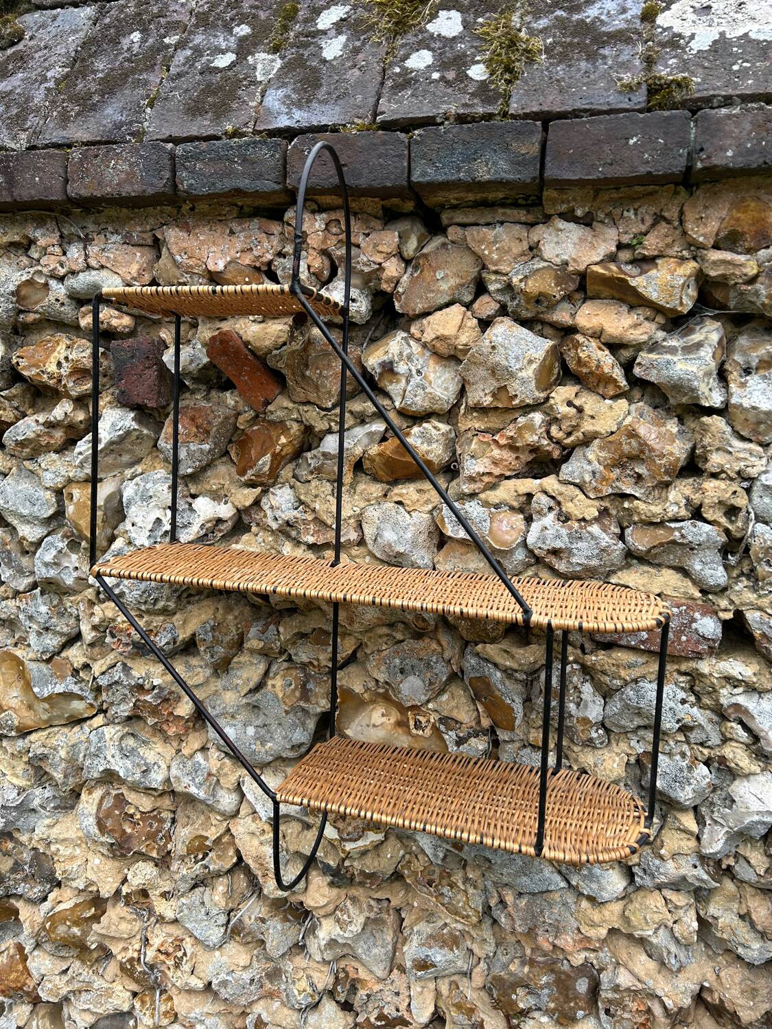 Wall shelf made of rattan and wrought iron