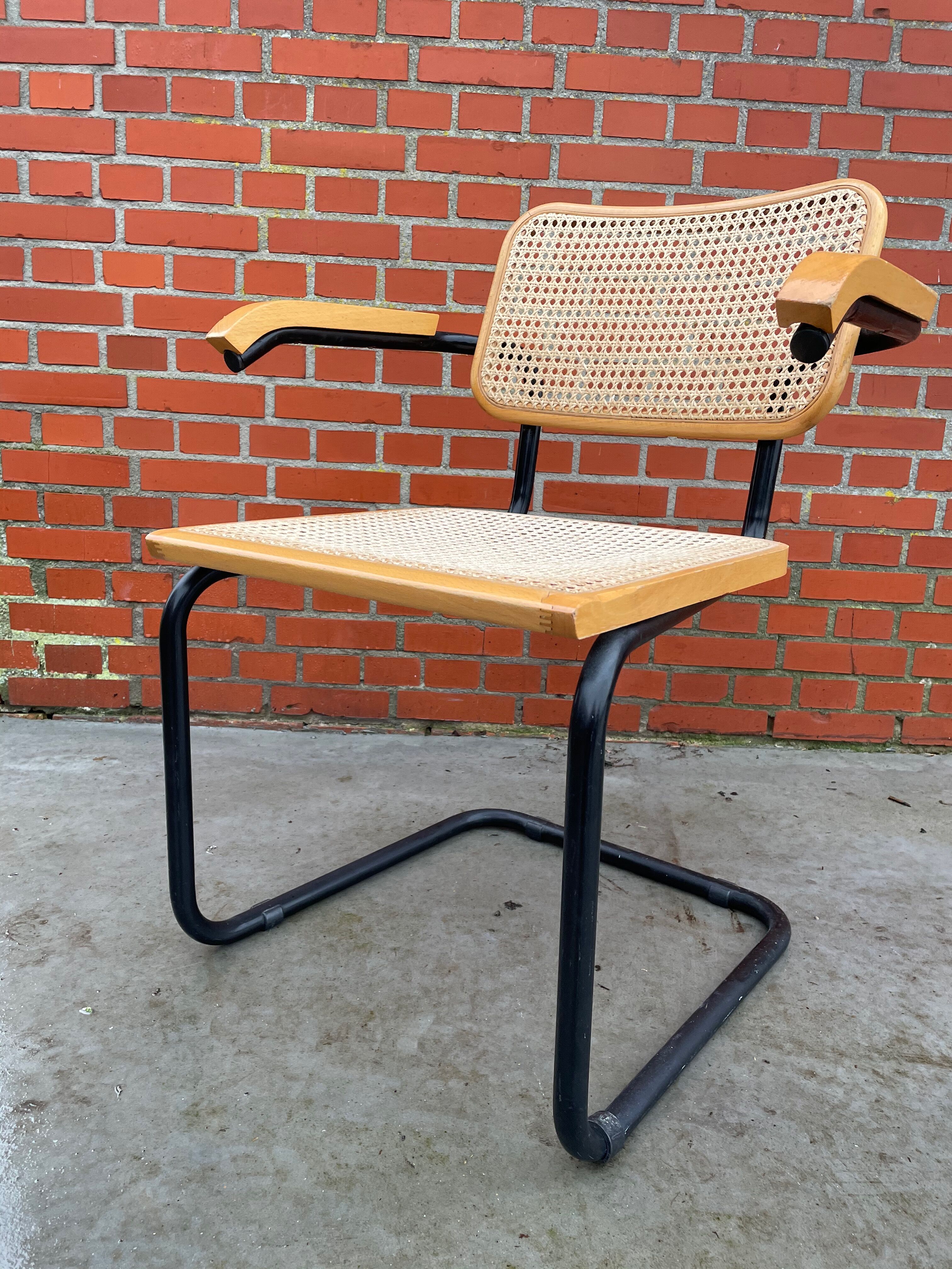 Cesca model chair designed by Marcel Breuer with black-framed armrests