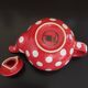 Pretty round English teapot with red polka dots.