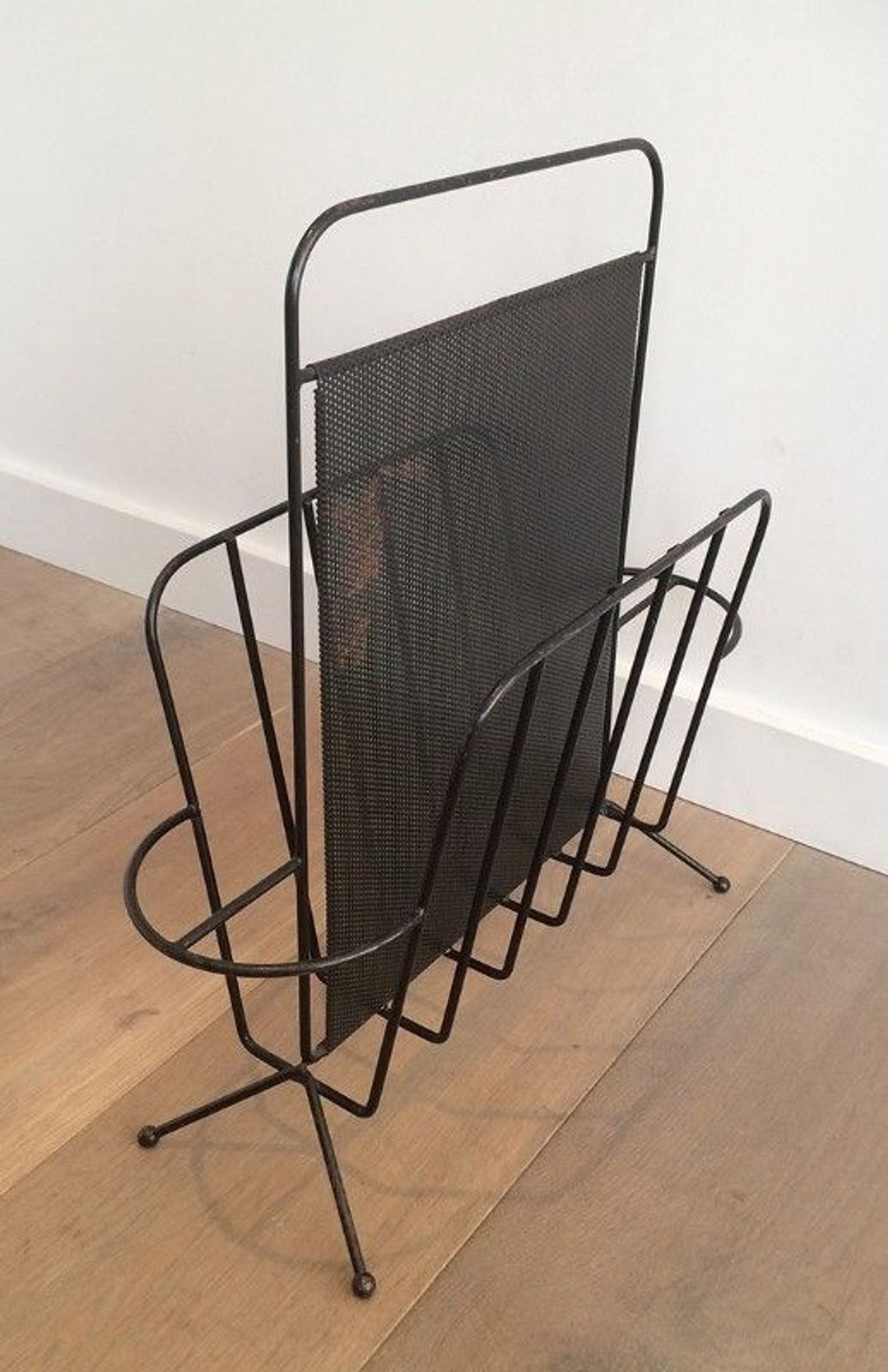 Black lacquered metal and perforated metal magazine rack designed by Mathieu Matégot 50.