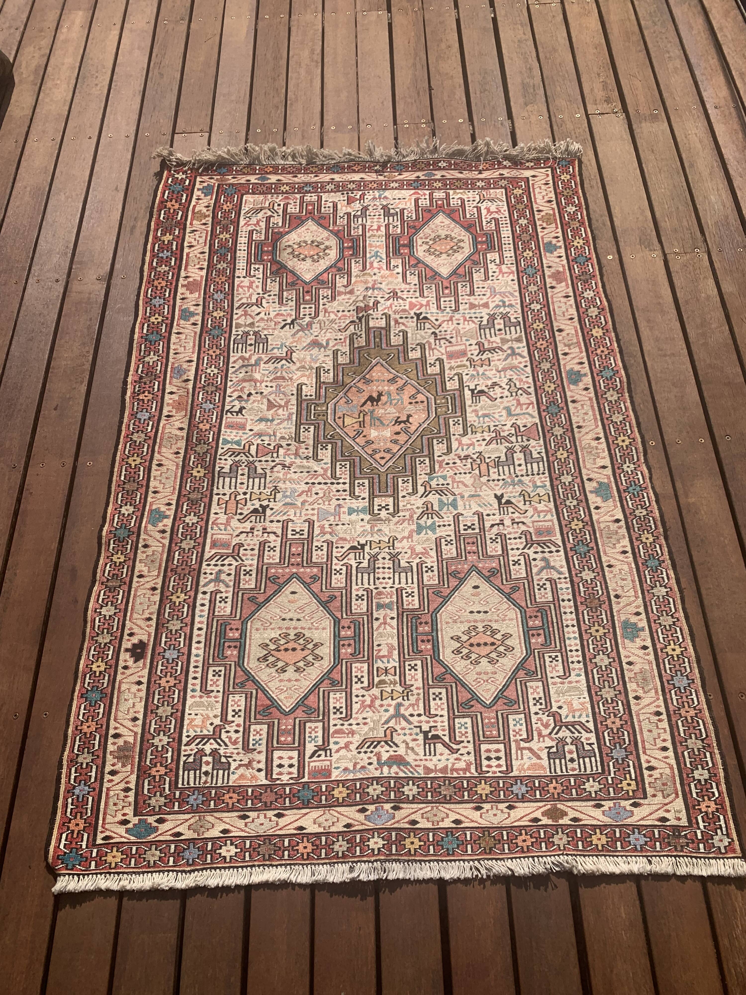 Hand-knotted silk carpet purchased in Iran – geometric and animal design –
