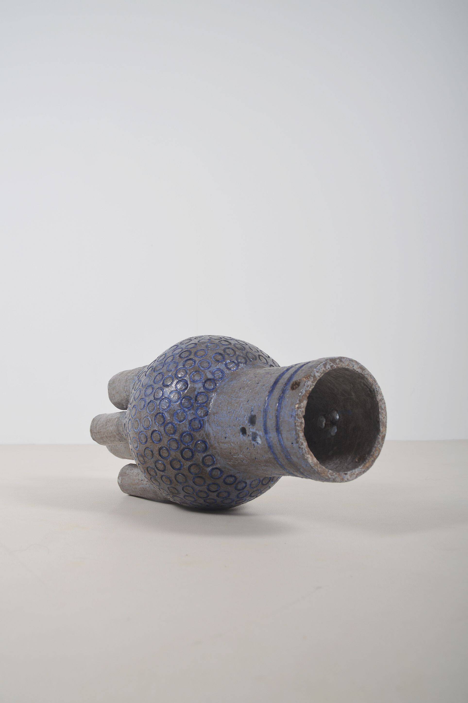 Sculpture en céramique avec des motifs circulaires et une signature.