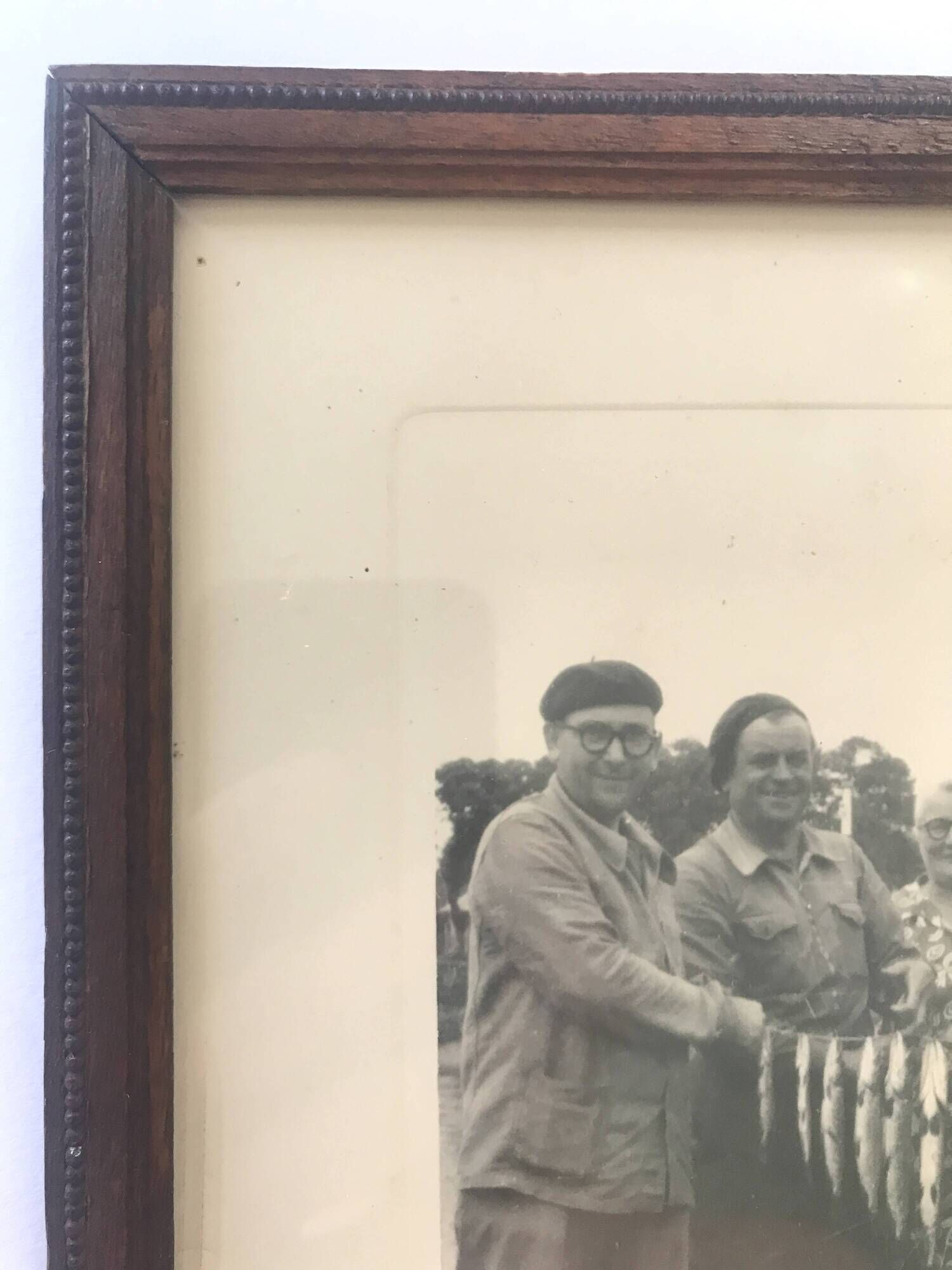 Fishing trophy with radiant faces, c. 1950. Black and white photograph.