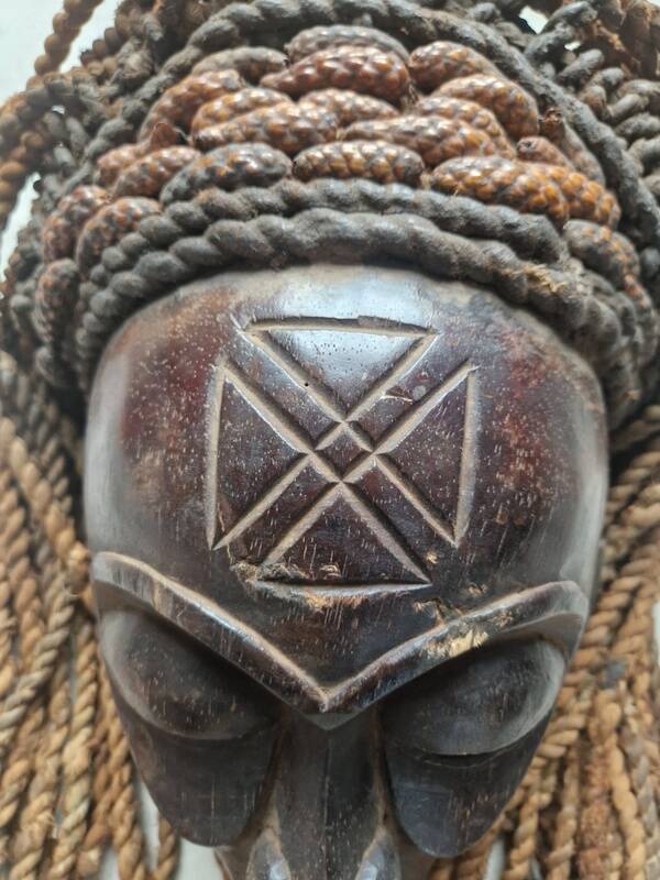 Chokwe Mwana Pwo mask in carved wood with a dark patina and rope hair
