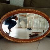 Antique oval mirror with beveled glass in wood and stucco, 19th century