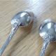 2 small white metal spoons
