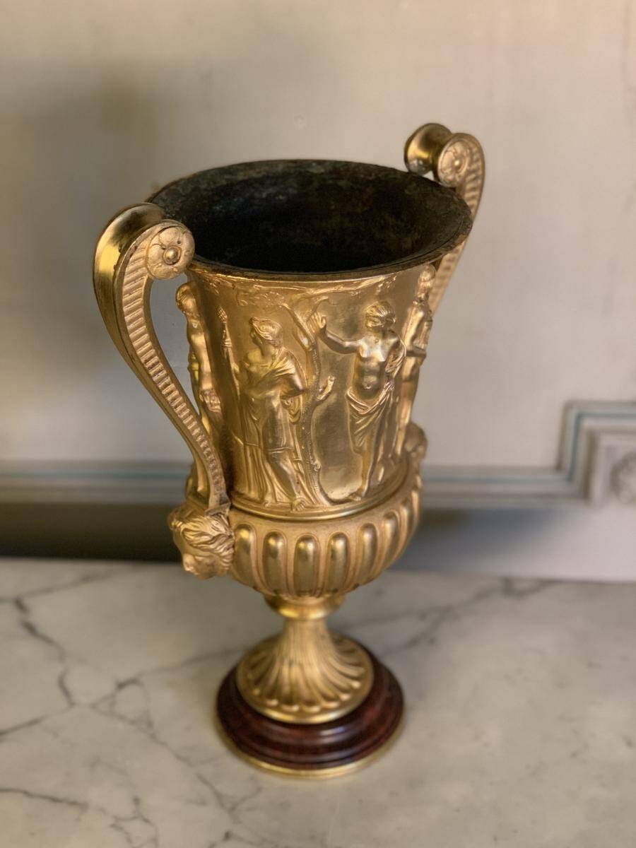 Golden bronze urn, base of red griotte marble.