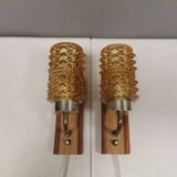 A set of wall lamps in teak wood, with amber colored glass