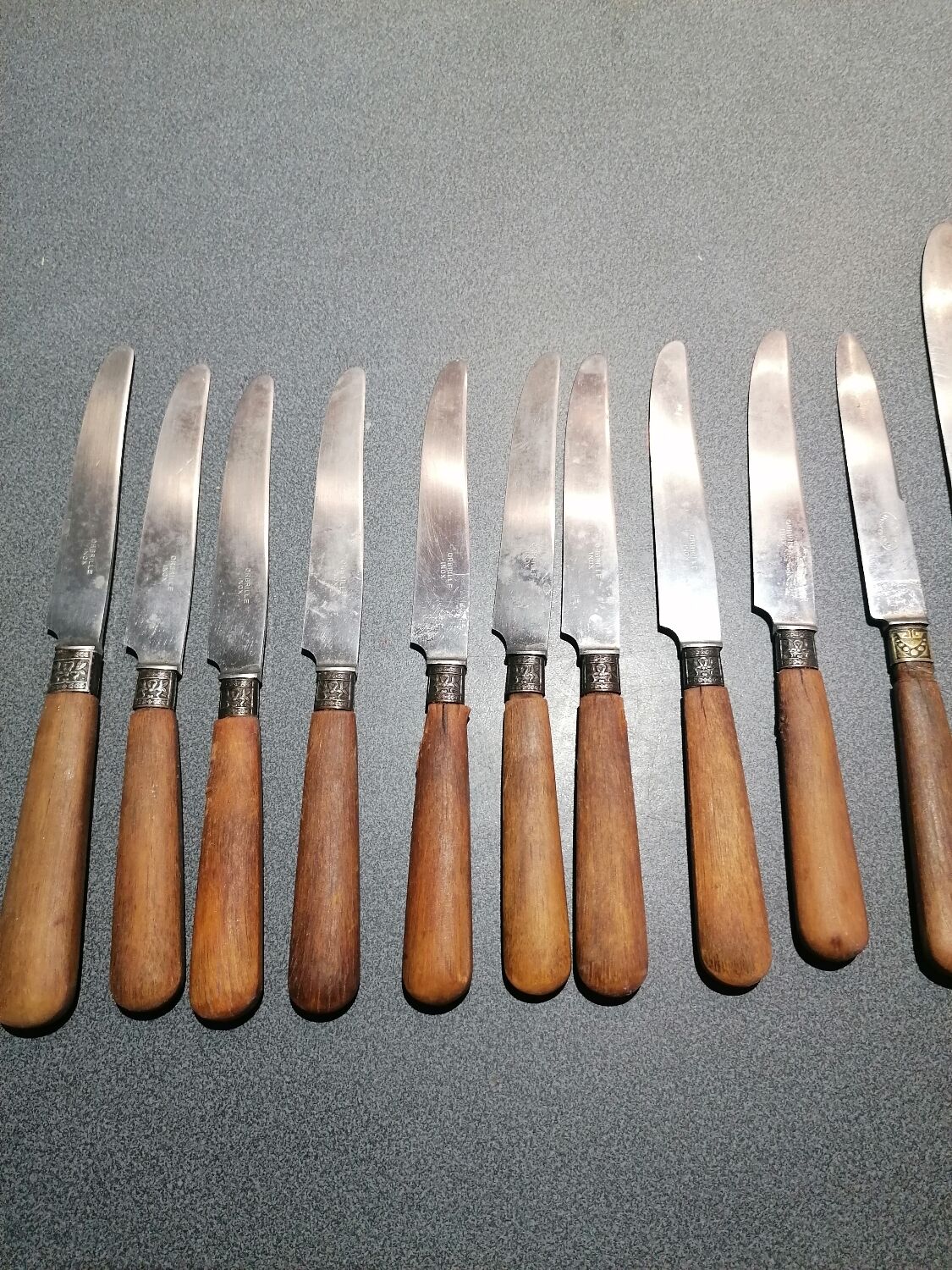 Old table knives and dessert knives, wooden handles, stainless steel blades