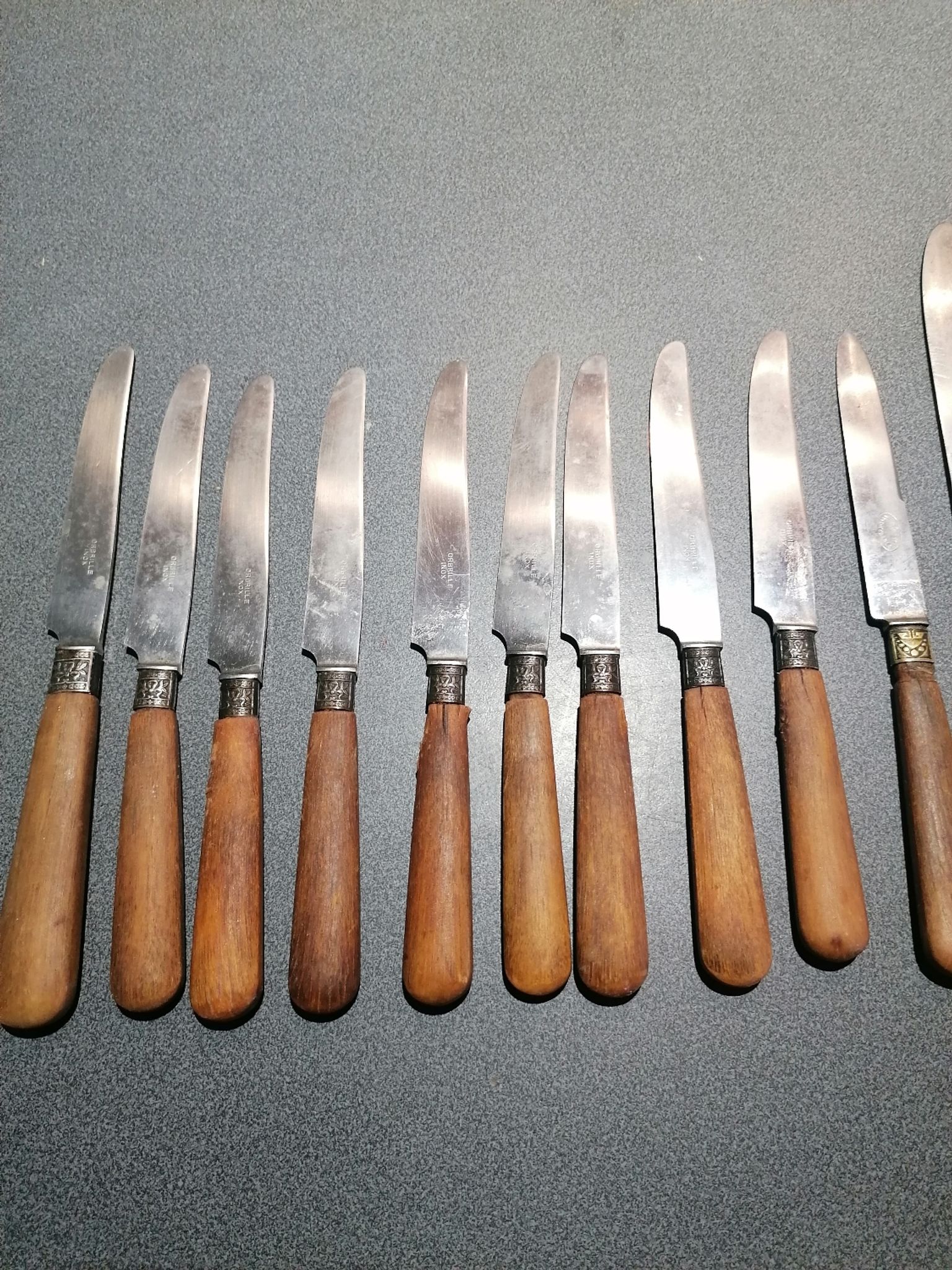 Old table knives and dessert knives, wooden handles, stainless steel blades