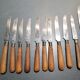 Old table knives and dessert knives, wooden handles, stainless steel blades