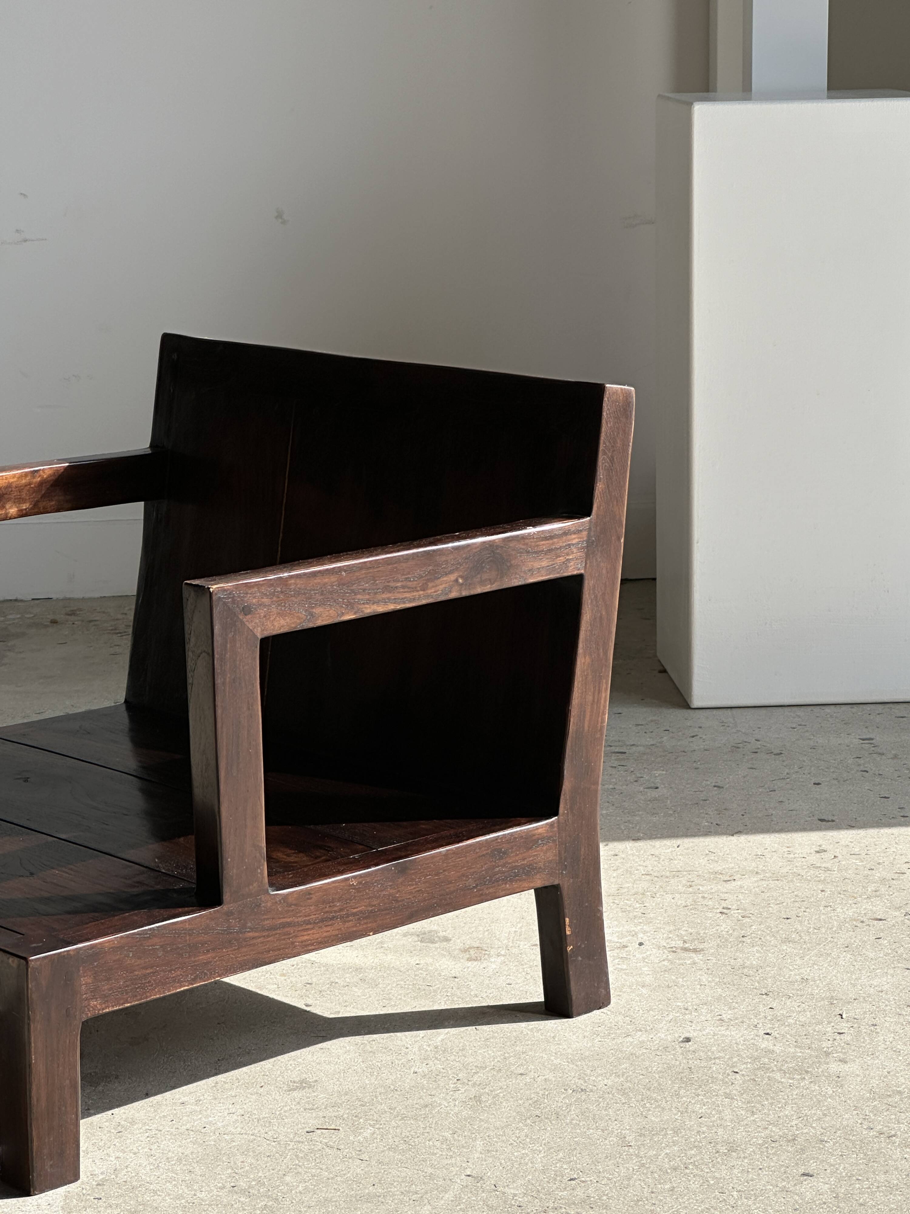 Small low armchair in varnished brown wood