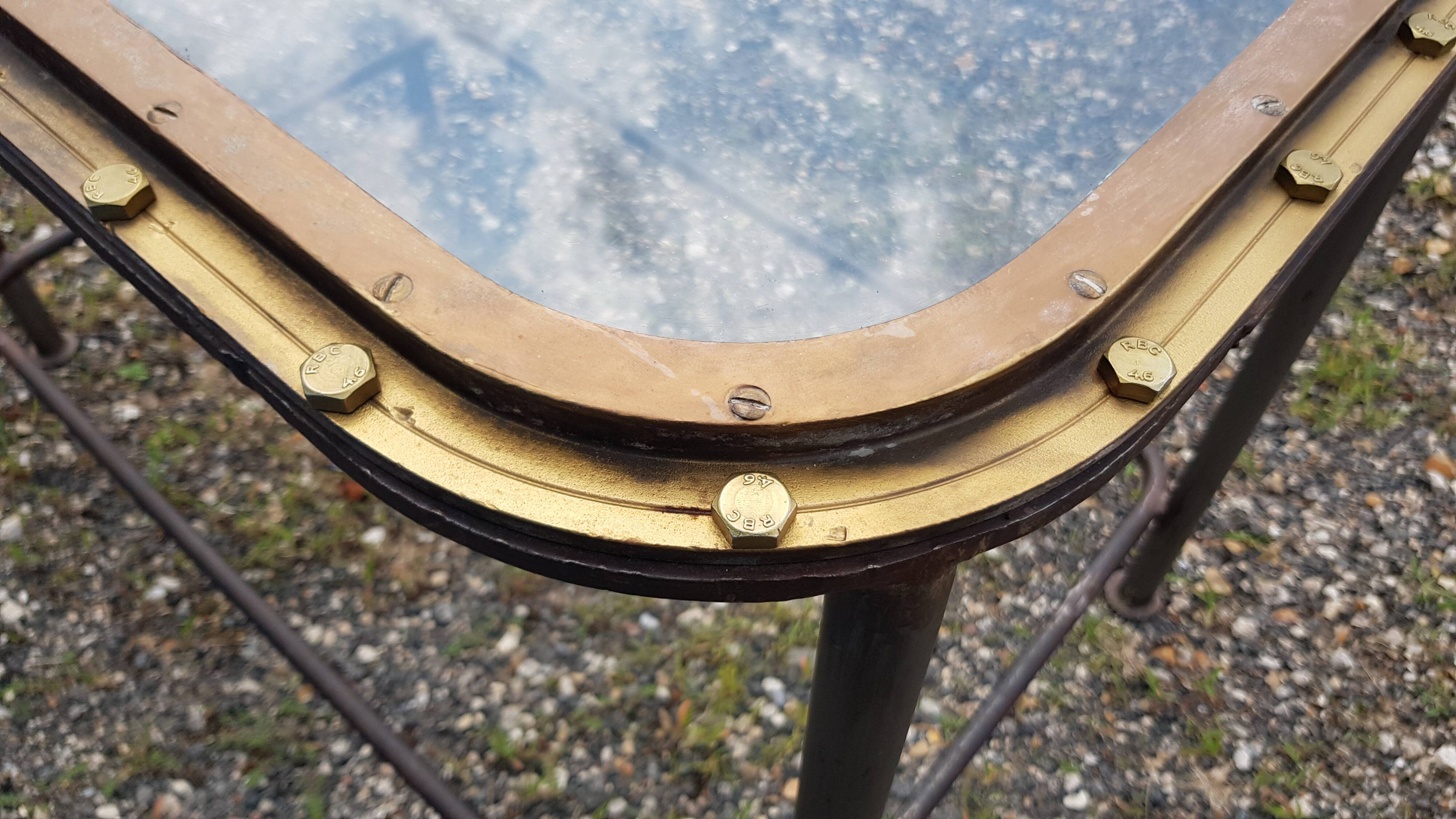 Table with an old ship porthole in brass and a metal base / 110 x 70 x 76 cm