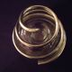 Round glass candle holder with silver-plated metal spiral.