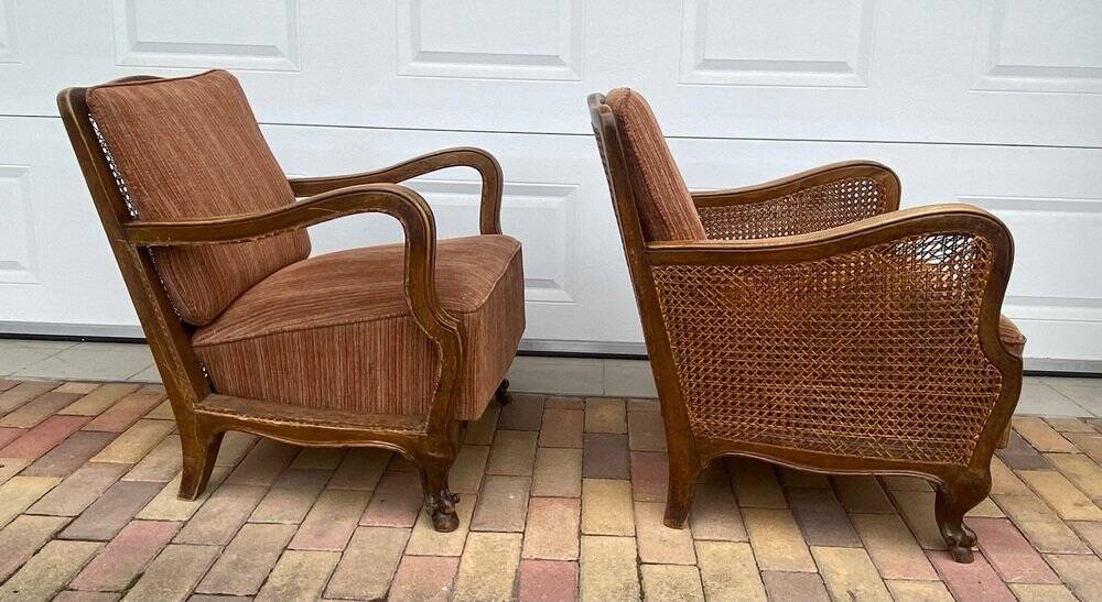 Pair of 1920s brown armchairs in carved wood and fabric, with caning detail.
