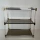 Lucite Shelf with Three Smoked Glass Shelves and Brass Ends. Work