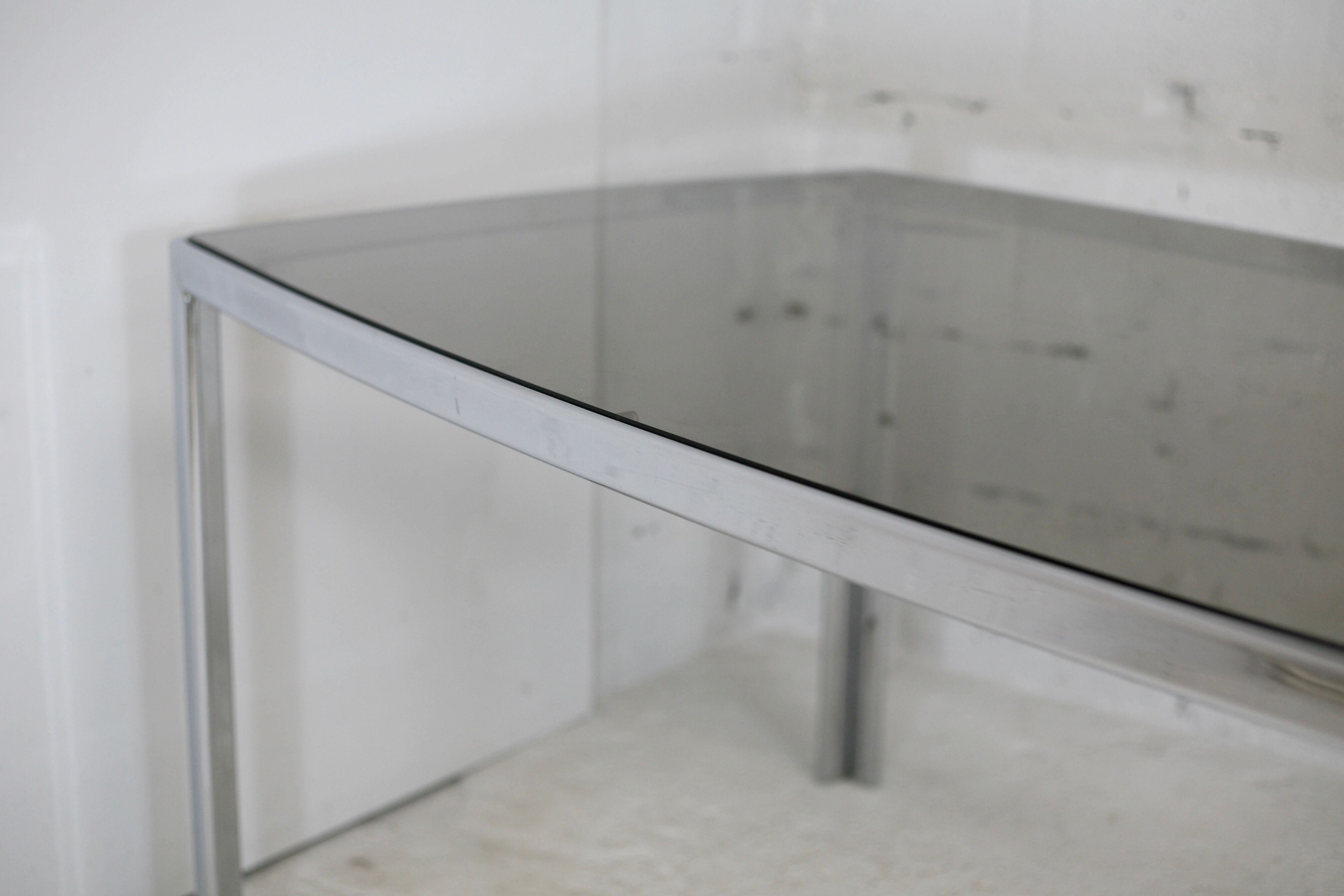 Living table. chrome metal, curved smoked glass slab, france, circa 1970.