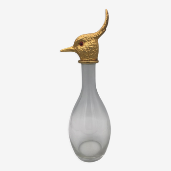 Carafe type glass bottle and golden metal bird's head cap