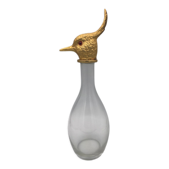 Carafe type glass bottle and golden metal bird's head cap