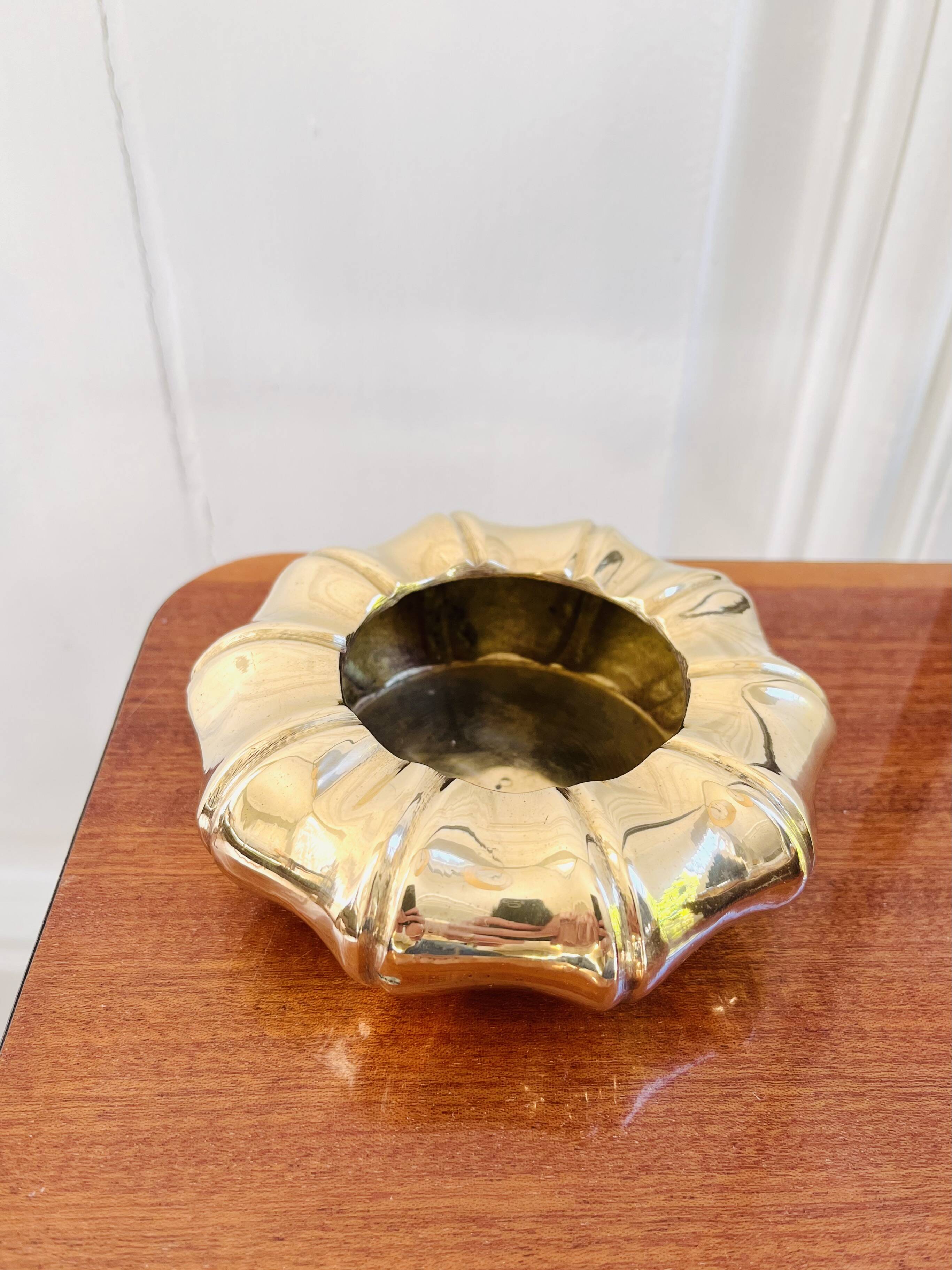 Golden brass ashtray with bamboo decoration.