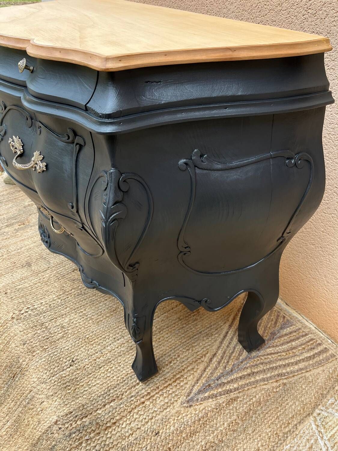 Curved commode painted in black and wood.